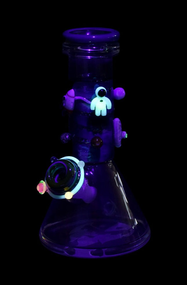 Front view of the Empire Glassworks Baby Beaker Water Pipe - Galaxy, displaying swirling blue and purple hues within its glass form.