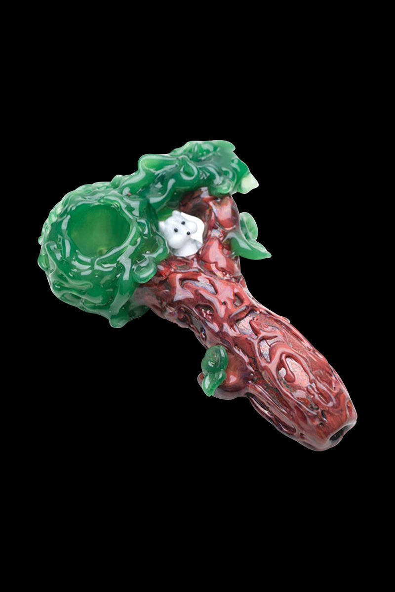 A three-quarter view of the Empire Glassworks "Squirrels Nest" spoon pipe, featuring a sculpted green and clear glass bowl.
