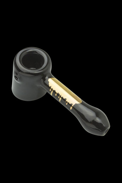 Front view of the Famous Brandz "Surrender" Hammer Hand Pipe, a darkly colored glass pipe with a unique curved design.