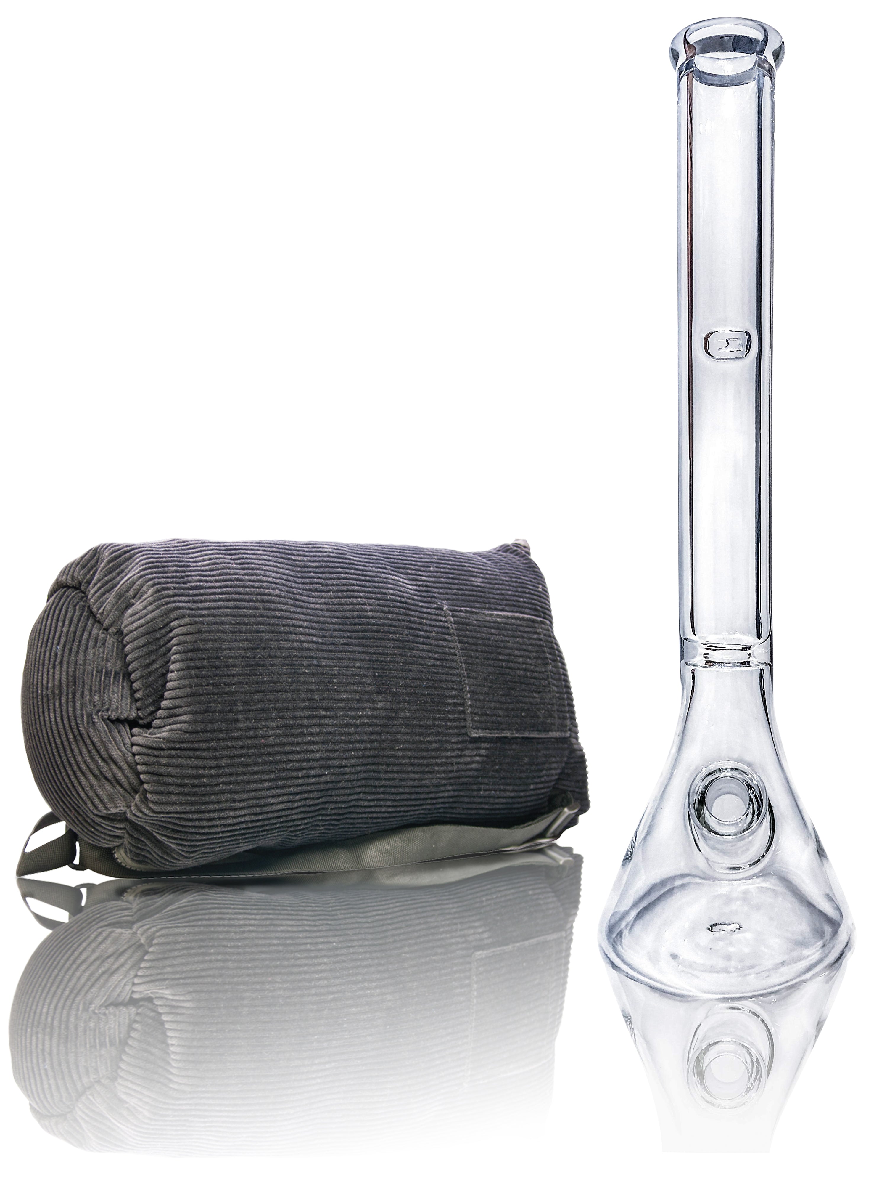 Front view of the Tank Glass "MAX" Beaker Bong with a dark-colored cylindrical object next to it on a reflective surface.