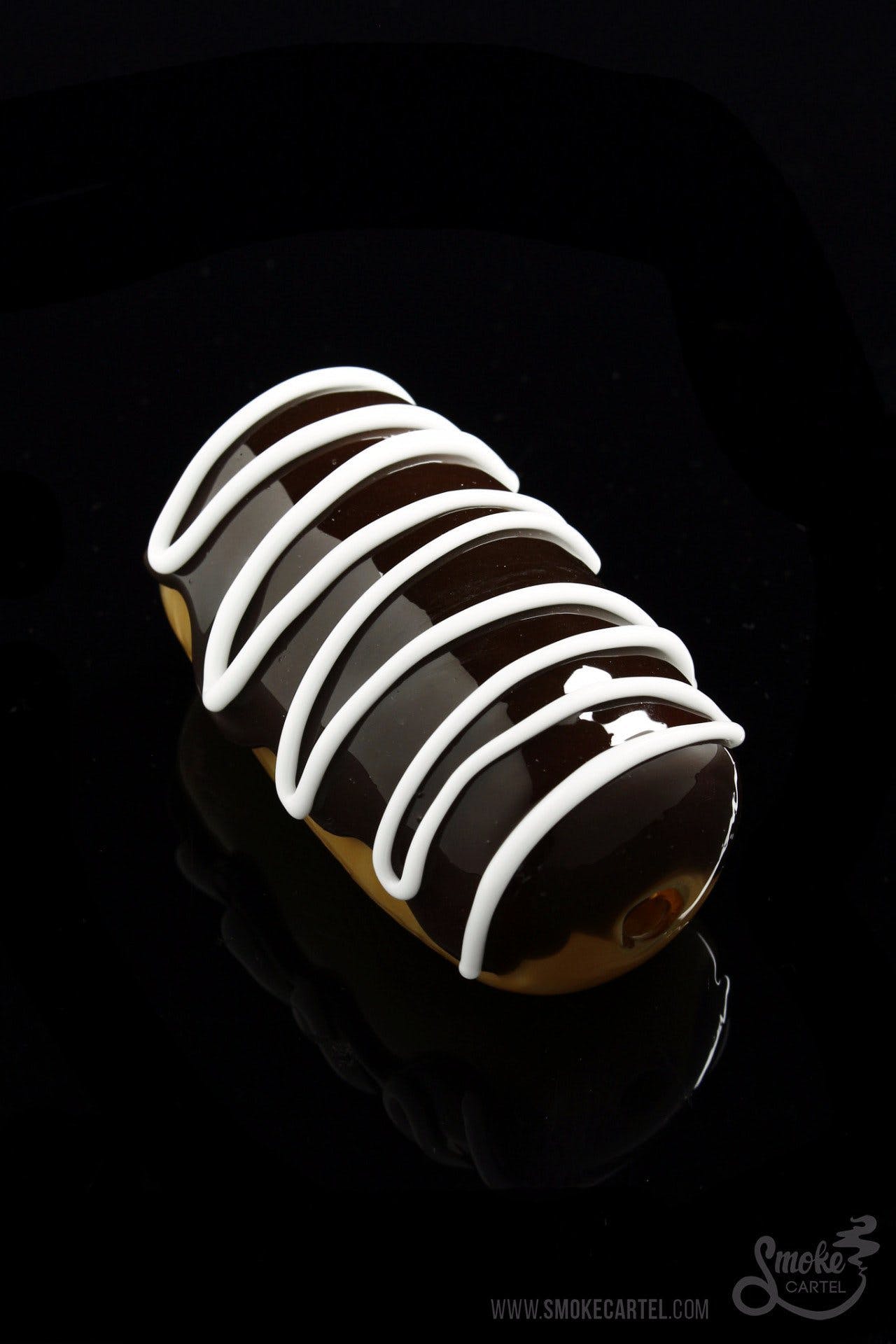 A close-up, angled view of the Glassheads "Sweet Eclair" Chillum, resembling a glazed pastry with its swirled glass design.