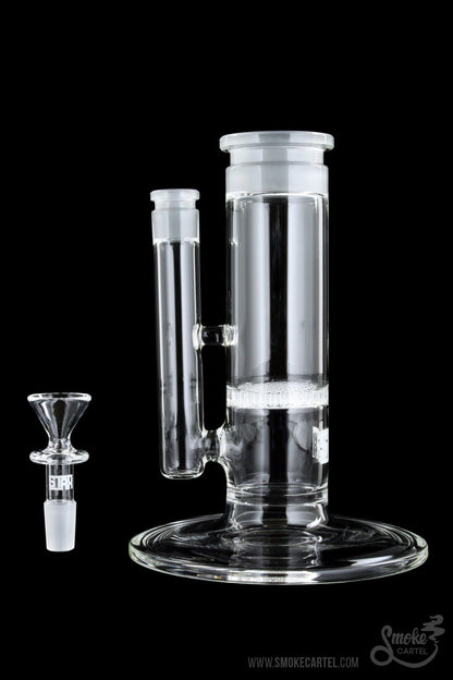 Clear glass bubbler water pipe with a glass bowl next to it on a black background.