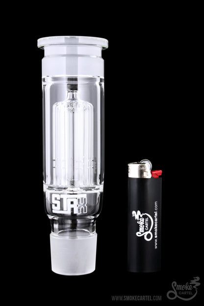Clear glass bubbler with ice pinches, next to a lighter, against a black background.