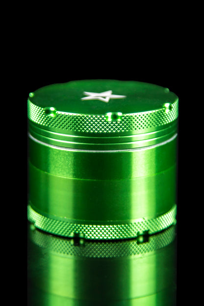 Close-up studio shot of the Famous X 4-Piece Grinder, showcasing its metallic finish and cylindrical shape.
