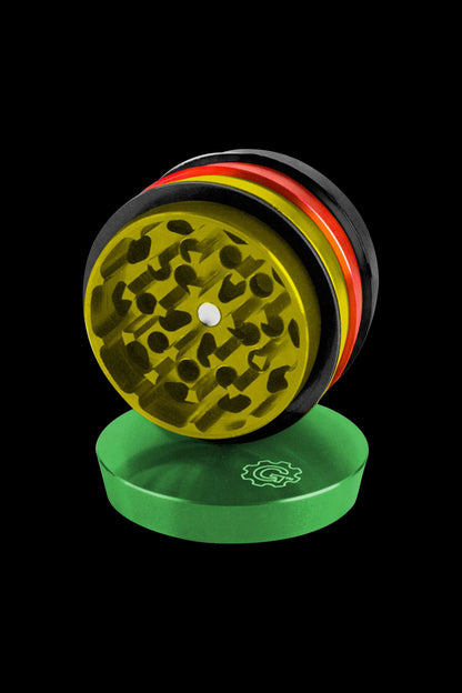 A high-angle view of the tiered, four-piece Pulsar 2 Aluminum Grinder, shown open on a solid green surface.