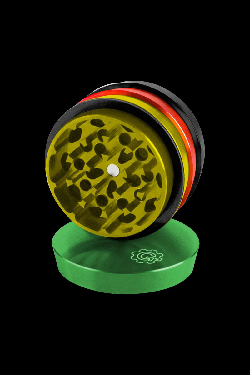 A high-angle view of the tiered, four-piece Pulsar 2 Aluminum Grinder, shown open on a solid green surface.