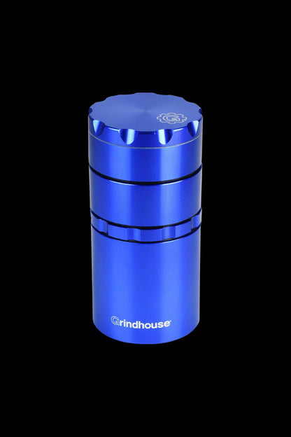 A close-up, angled view of the Pulsar Metal Storage and 4-Piece Grinder, showcasing its metallic blue finish and multi-tiered design.