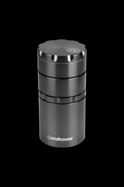 A sleek, metallic Pulsar Metal Storage and 4-Piece Grinder is displayed in a close-up, angled shot against a dark background.