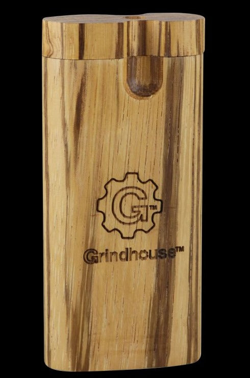 A close-up, angled view of the Pulsar Straight Zebrawood Dugout, showcasing its wood grain and twist-top design.