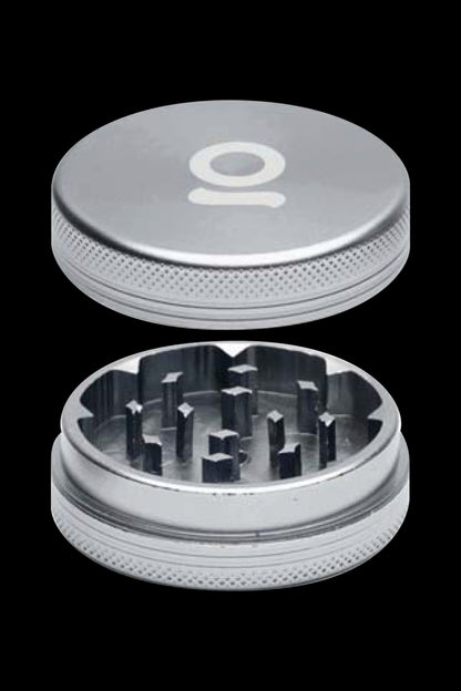 Silver cannabis grinder with two separated parts, top and bottom, showcasing the teeth for grinding.