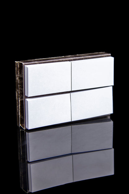 White cannabis pre-roll packaging with a reflective surface, displayed against a black background.