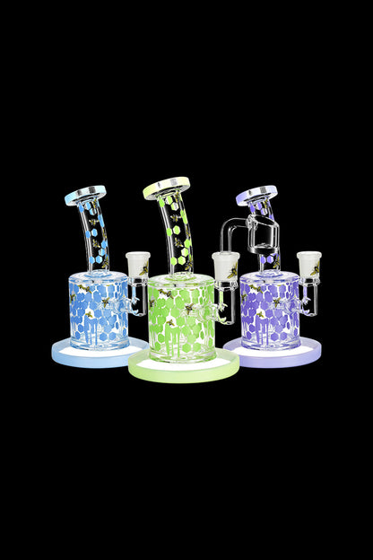 A side view of the Honeycomb Drip Dab Rig, showcasing its clear glass construction with vibrant blue and green accents.