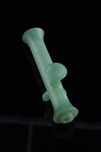 Frosted green glass pipe against a black background.