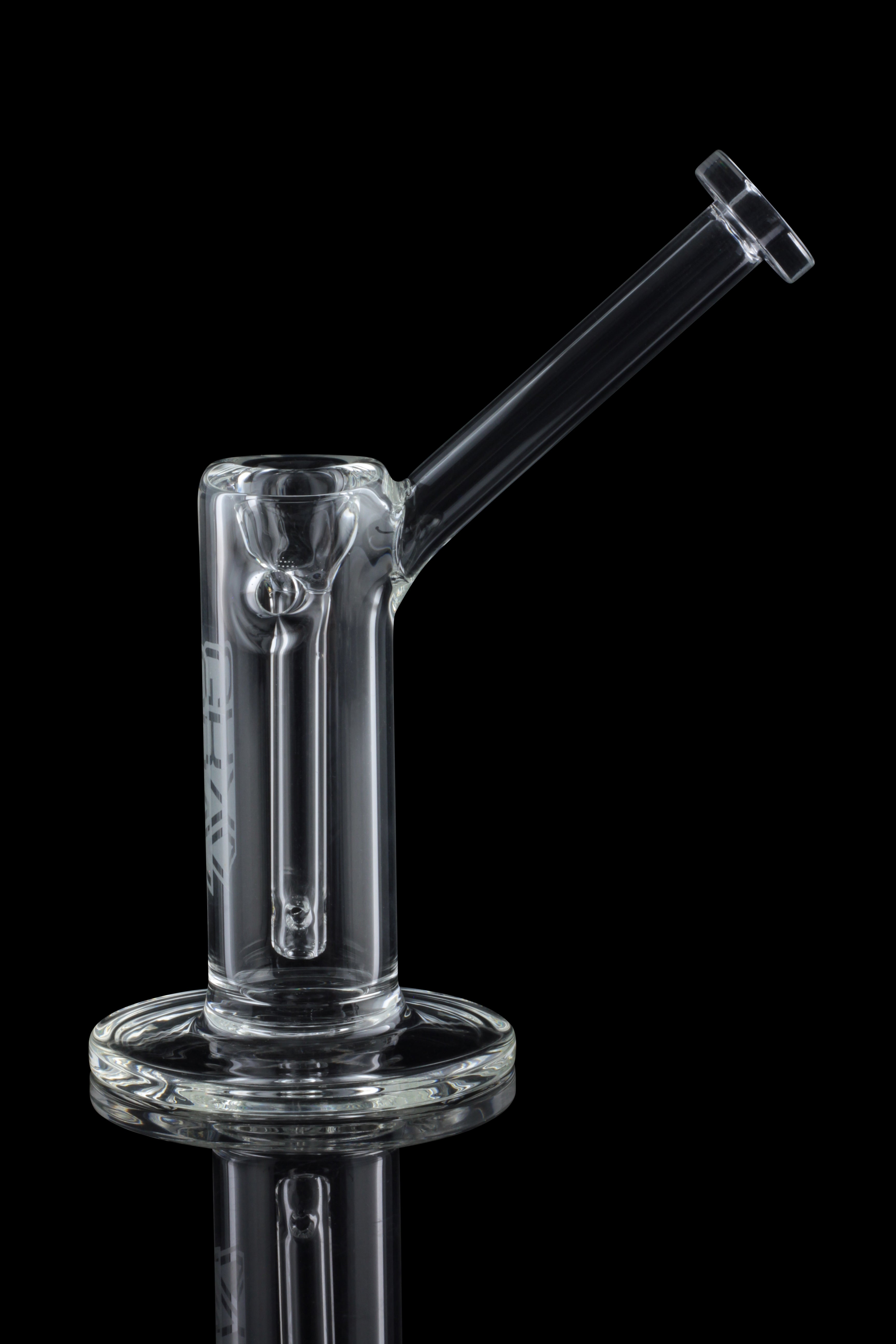 Clear glass dab rig with a circular base and angled mouthpiece, reflecting on a dark surface.