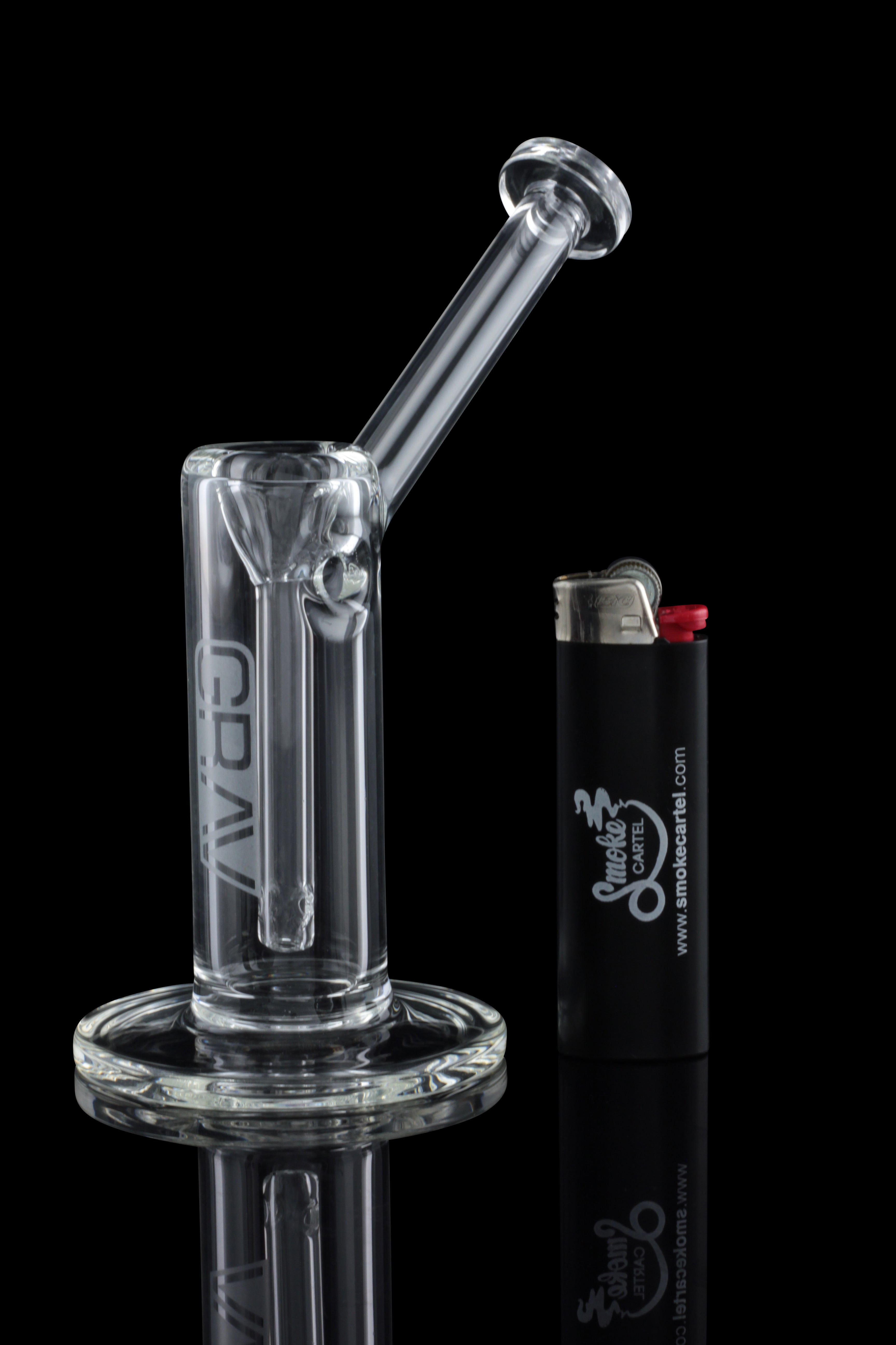 Clear glass oil rig with a lighter, reflected on a black surface.