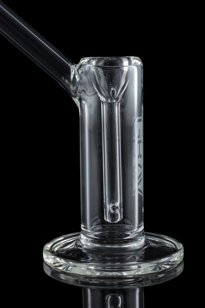 Clear glass oil rig with a circular base, featuring a downstem and angled mouthpiece, against a black background.