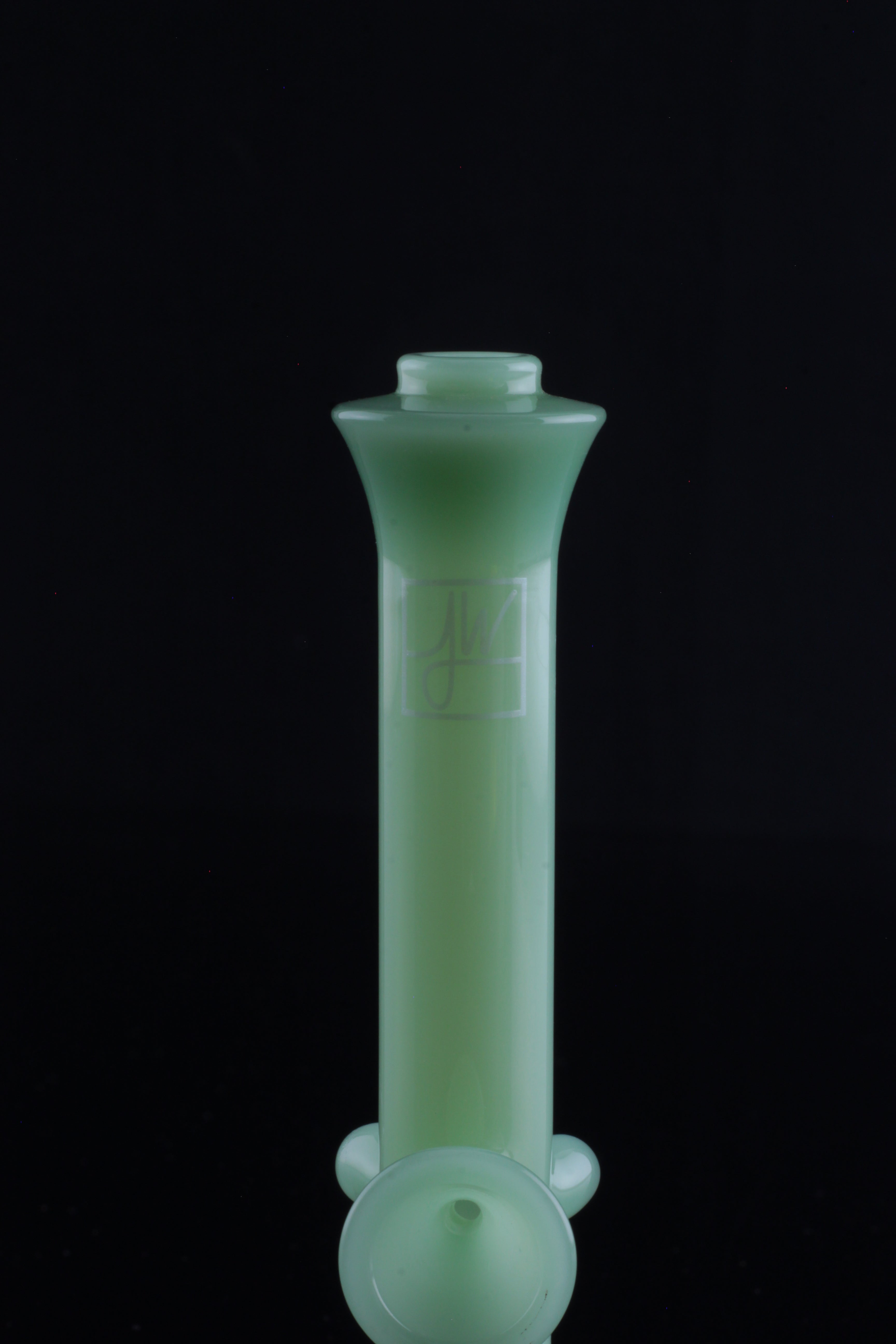 Green glass water pipe (bong) isolated on a black background.