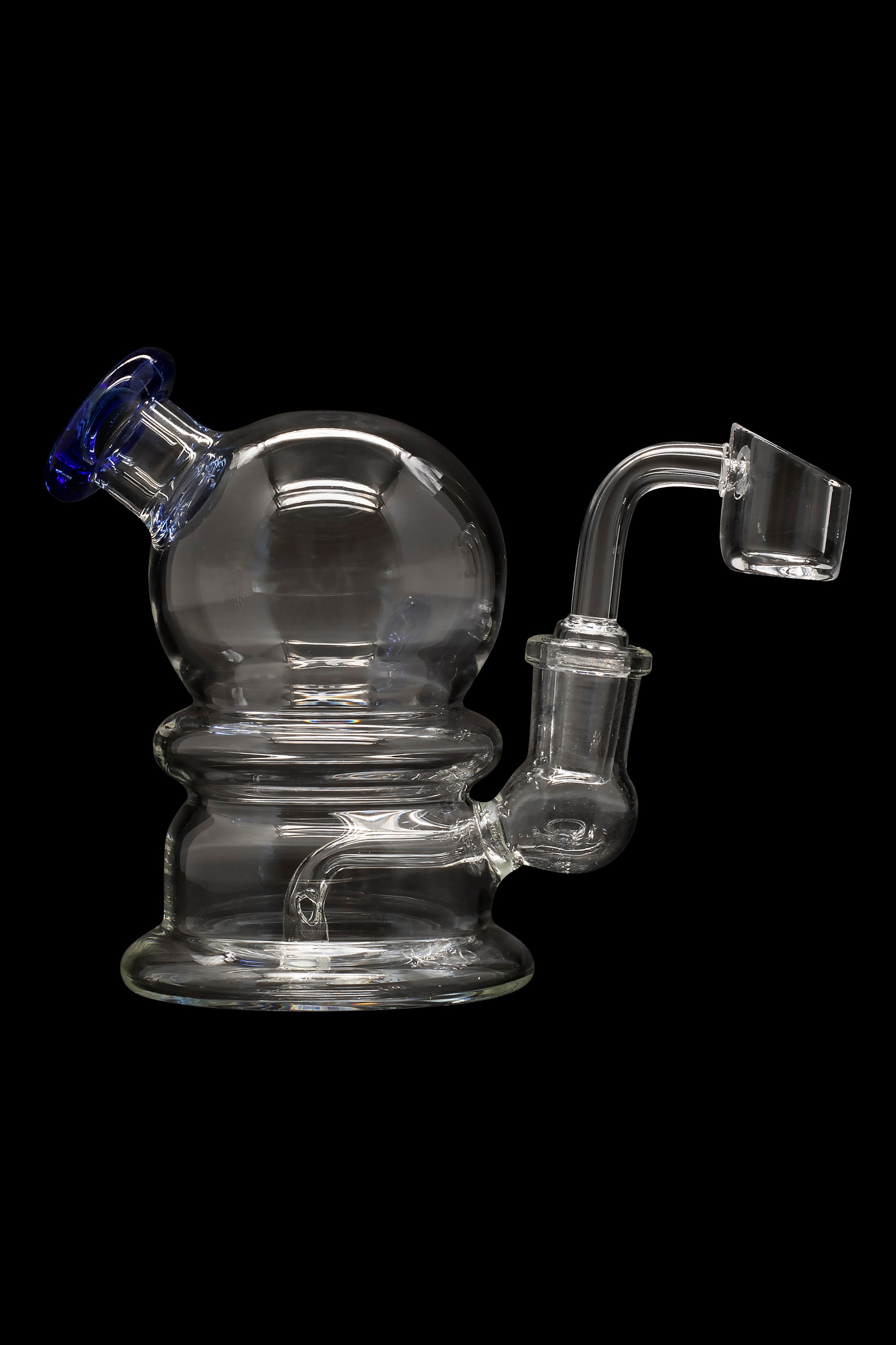Clear glass dab rig with a spherical body and quartz banger, isolated on a black background.