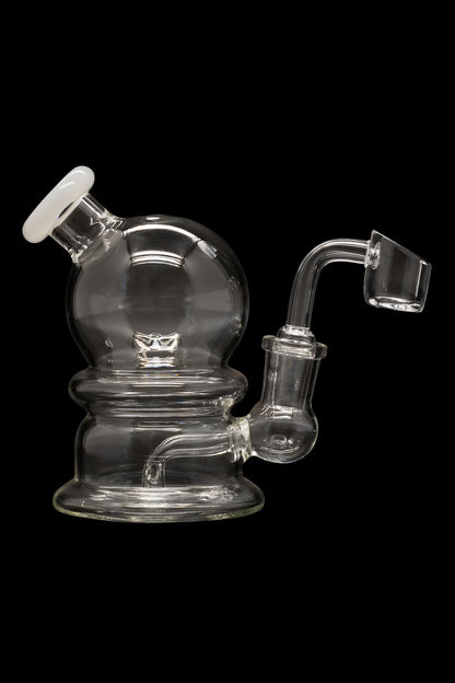 Clear glass dab rig with a quartz banger, isolated on a black background.