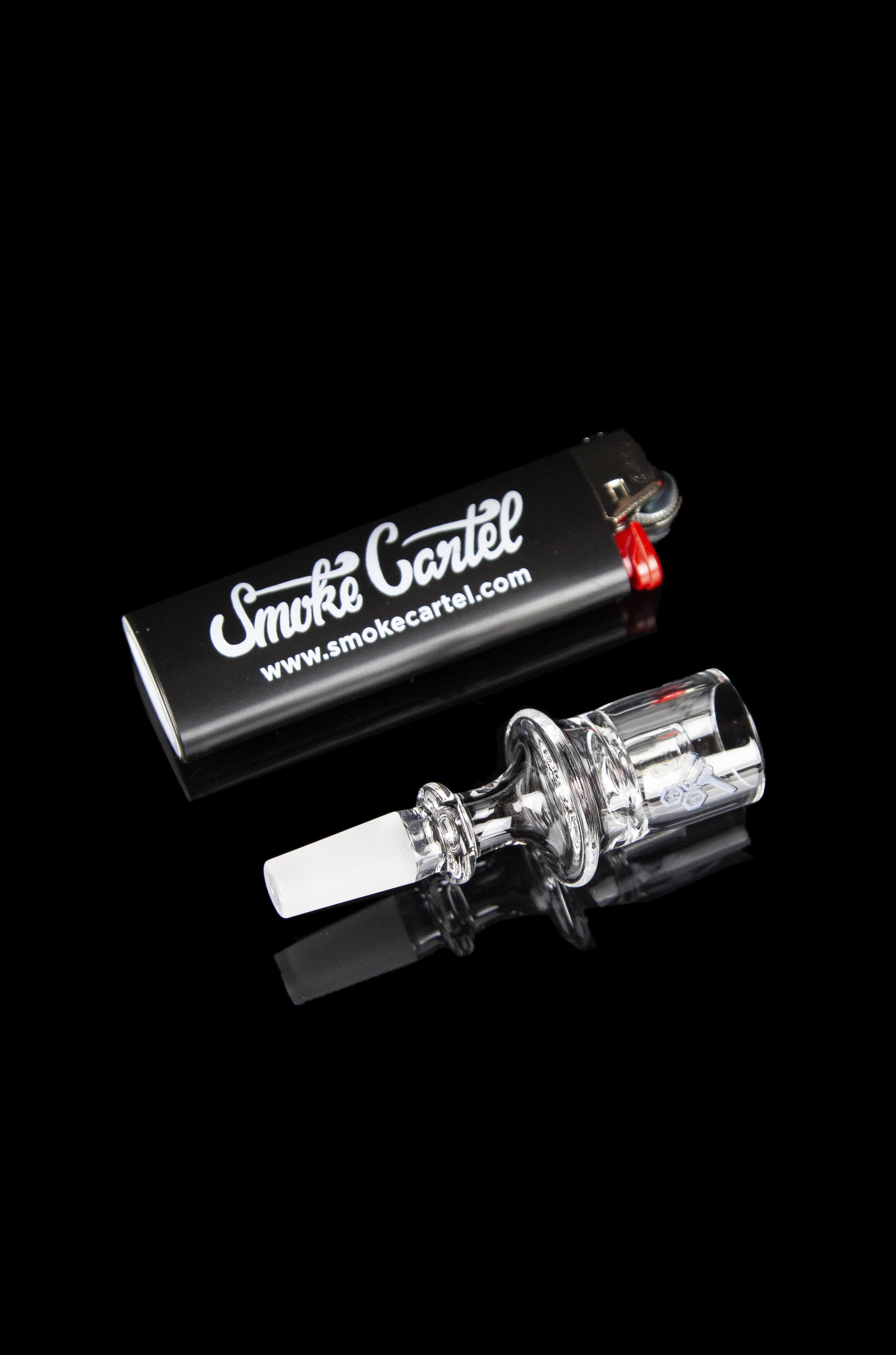 Glass bubbler pipe with “Smoke Cartel” branded packaging on a reflective black surface.