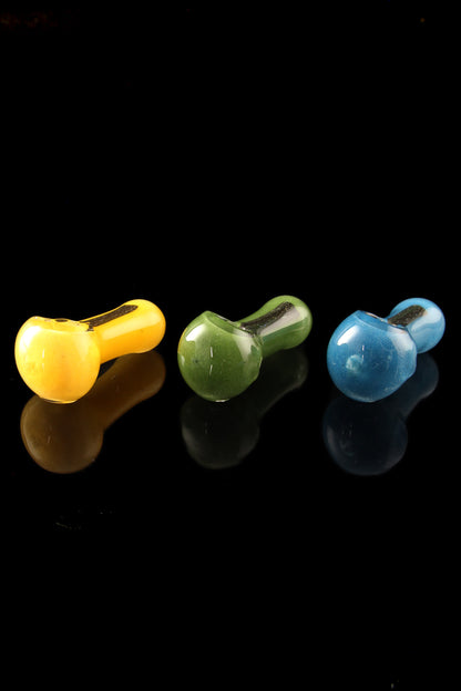 Three colorful glass smoking pipes—yellow, green, and blue—displayed against a black background.