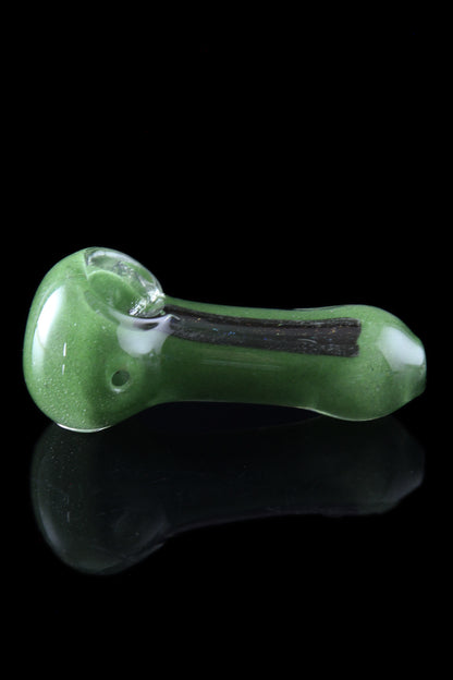 Green glass pipe with black accents, reflecting on a glossy surface.