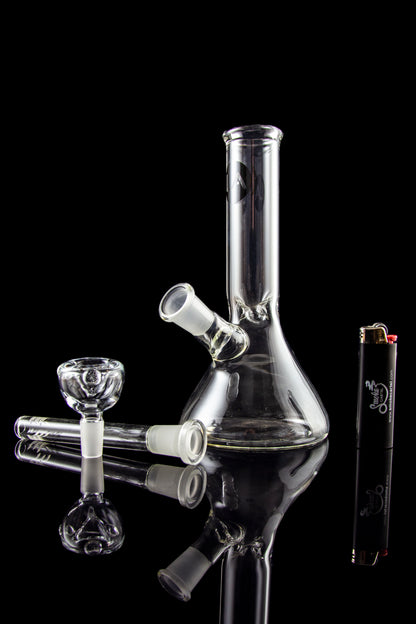 A studio shot of the LA Pipes Basic Beaker Water Pipe - Simply Guy, showcasing its clear glass construction in a downward-angled view.