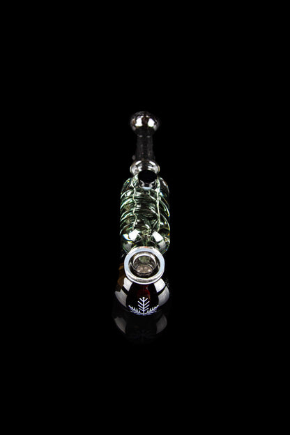 Glass cannabis oil rig with intricate green and white detailing, displayed against a black background.