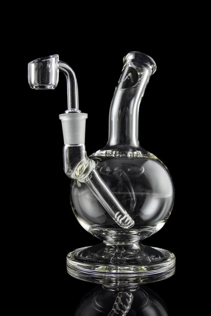 Clear glass dab rig with intricate design and accompanying nail, isolated on a black background.