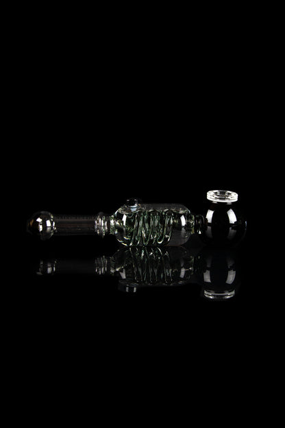 Clear glass rig with intricate bubbler design, reflecting on a dark surface.