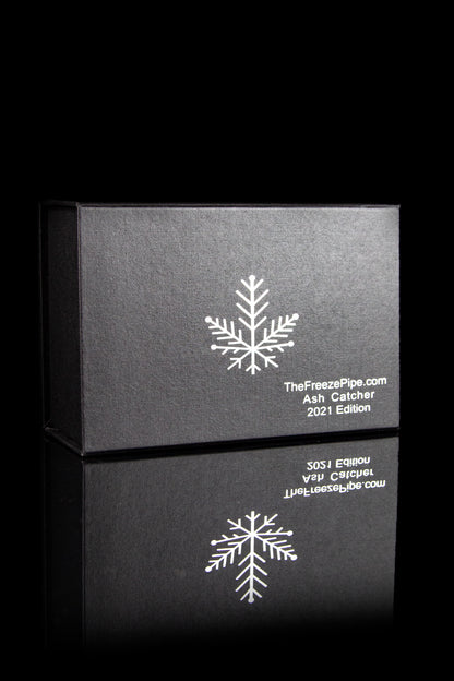 Black boxes with snowflake designs and branding for “TheFreezePipe.com Ash Catcher 2021 Edition.”