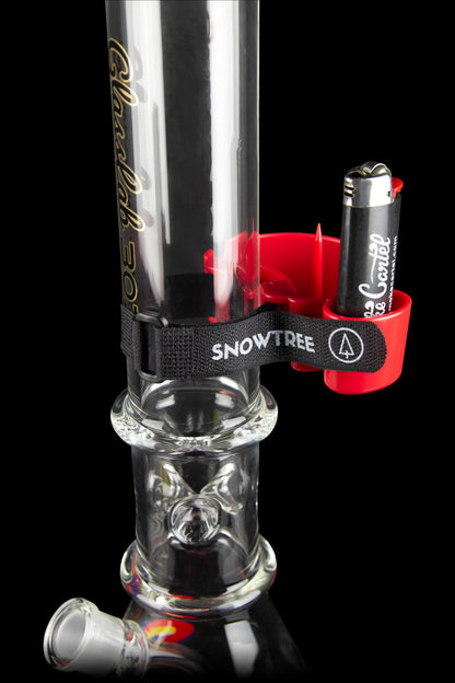 A glass water pipe (bong) with intricate bubble detailing, featuring a red accent and branded with “Snowtree”. A small black lighter is clipped to the neck of the pipe.