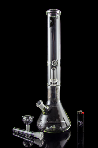 Clear glass bong with various attachments and accessories, reflecting on a black surface.