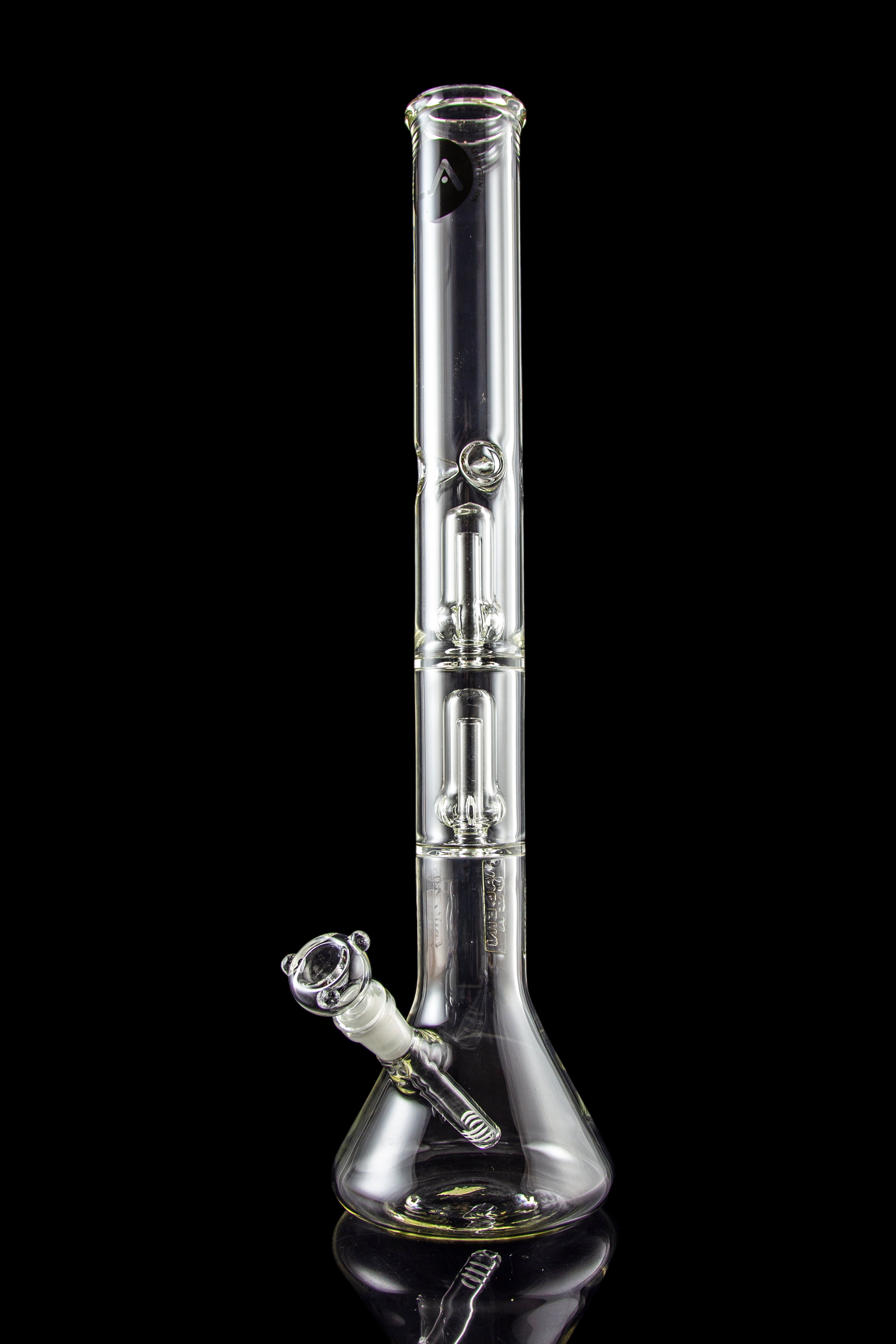 Clear glass bong with intricate bubbler and reflective surface against a black background.