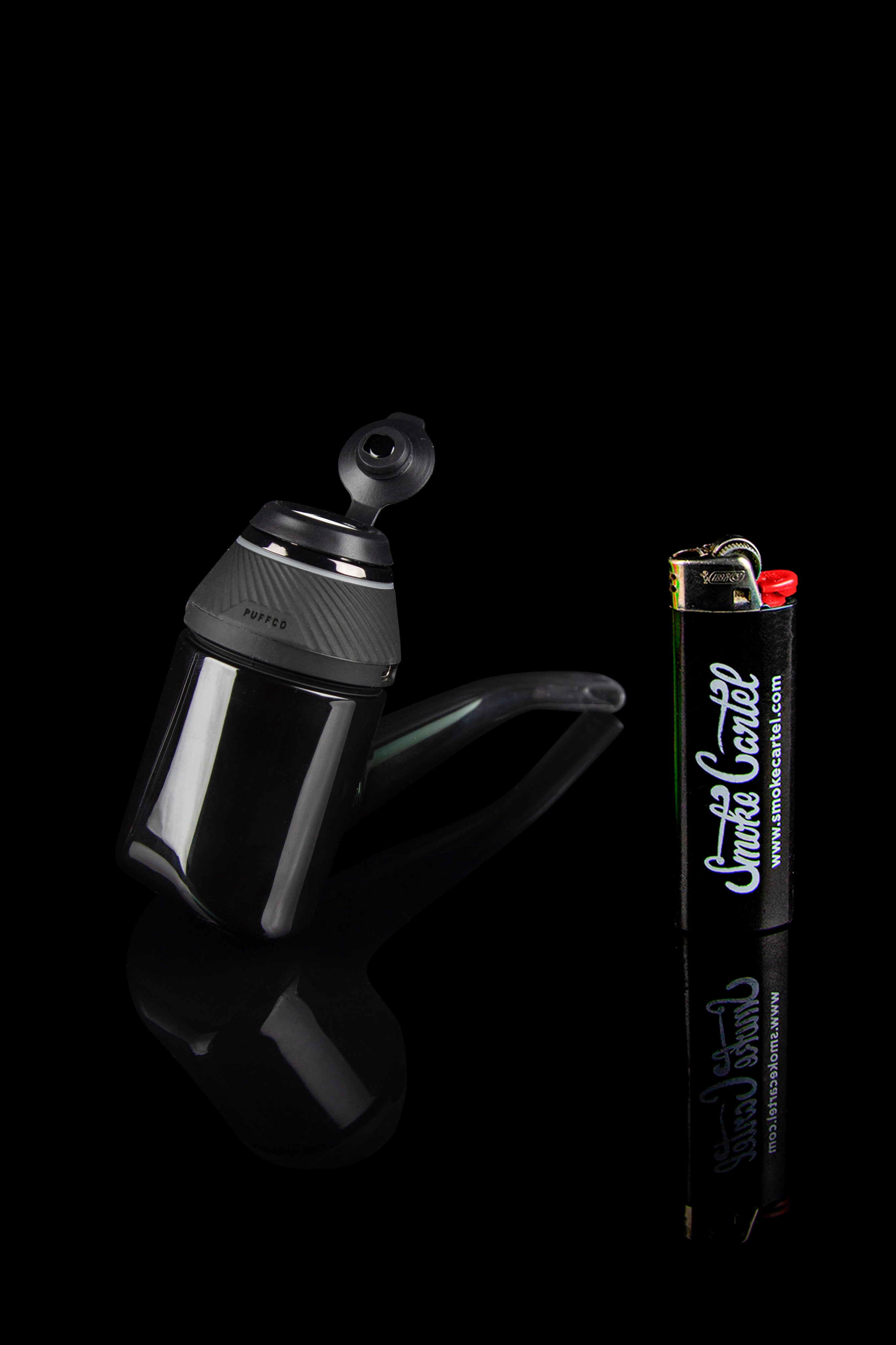 Black cannabis oil press and lighter with “Smoke Cartel” branding against a dark background.