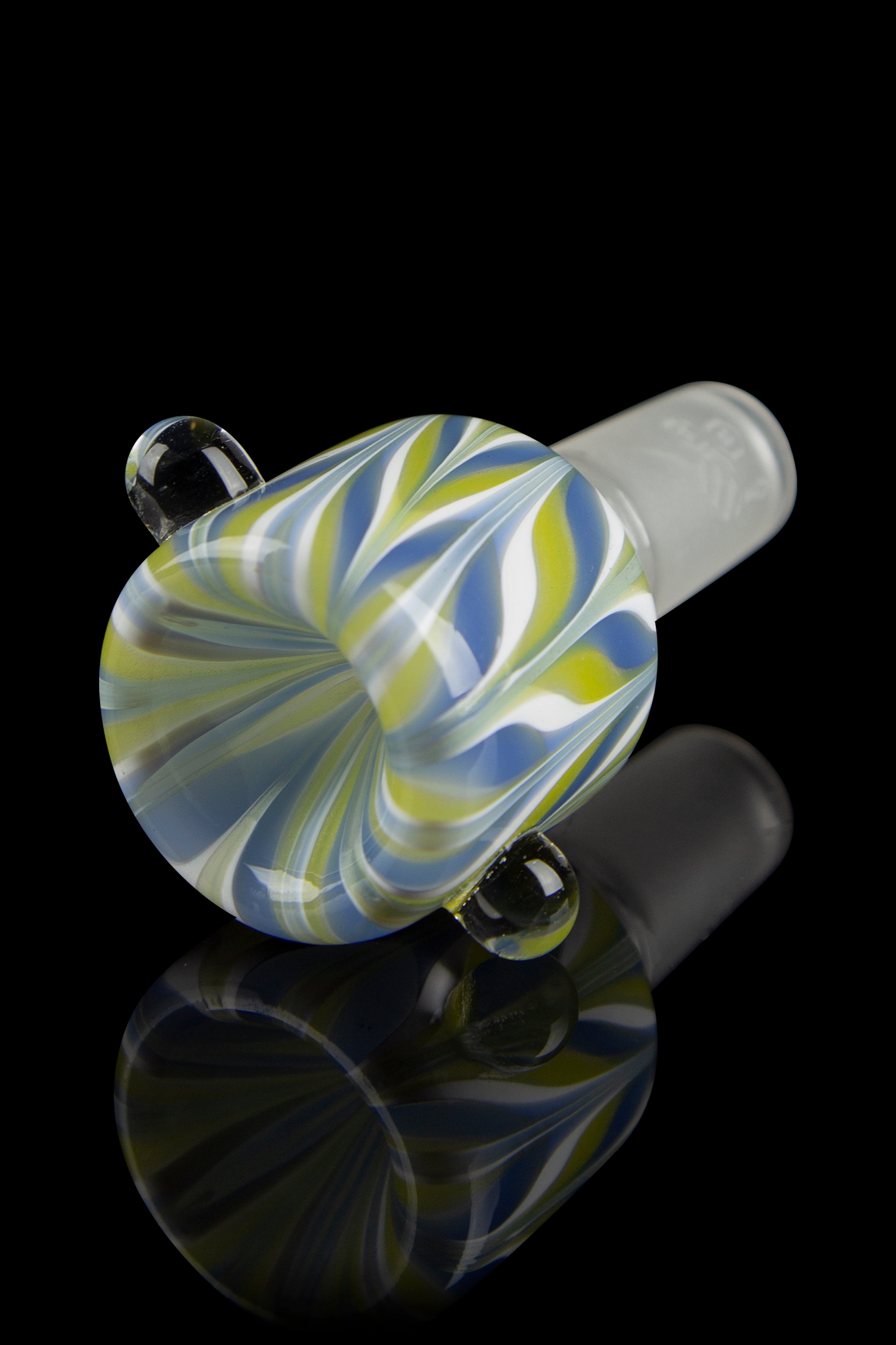 Angled close-up of the Honeybee Herb Wig Wag Flower Bowl showing lime-green, blue, and white swirling stripes and its glossy reflection on black.