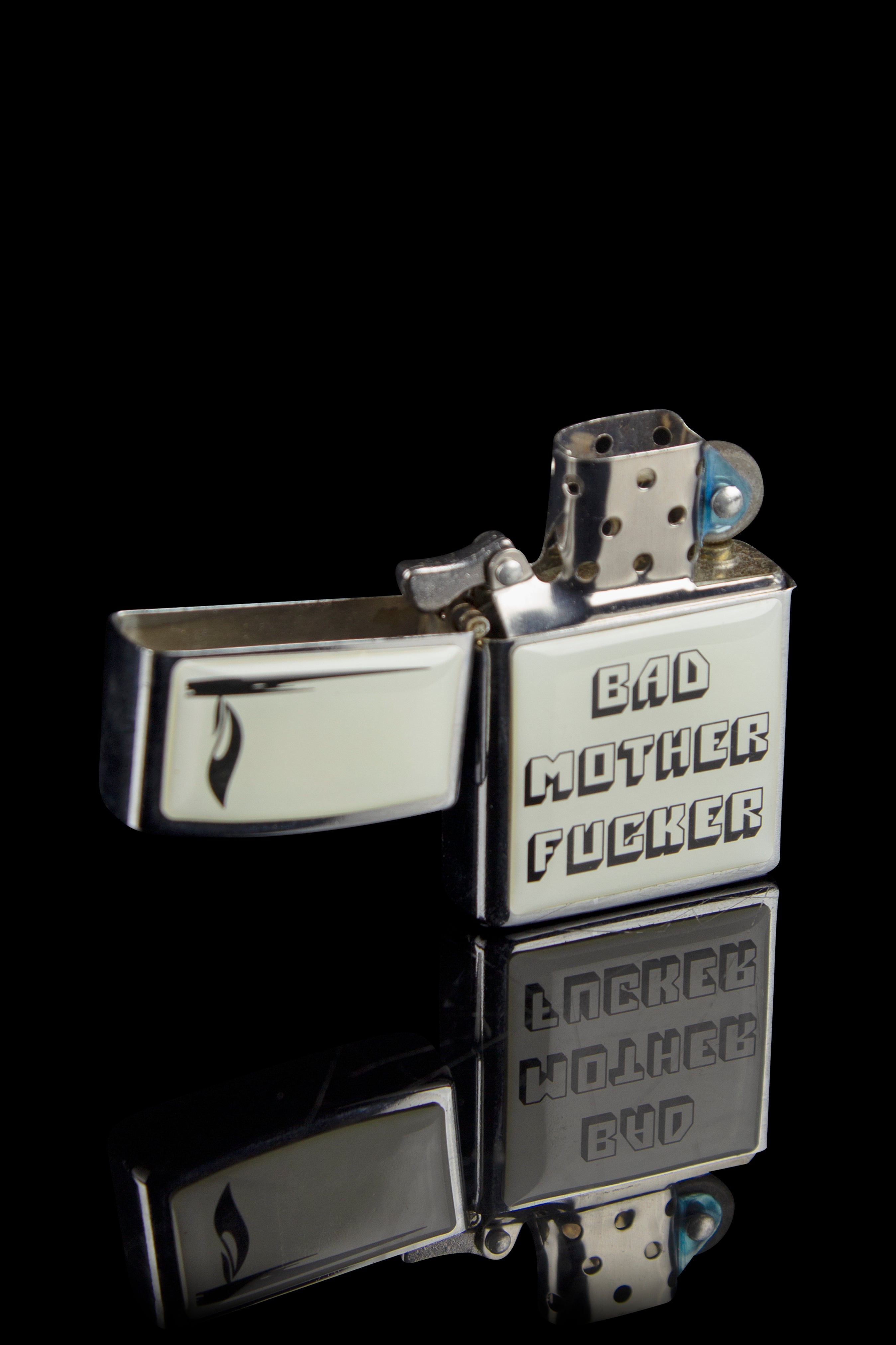 Silver Zippo-style lighter engraved with cannabis-themed profanity and imagery against a black background.