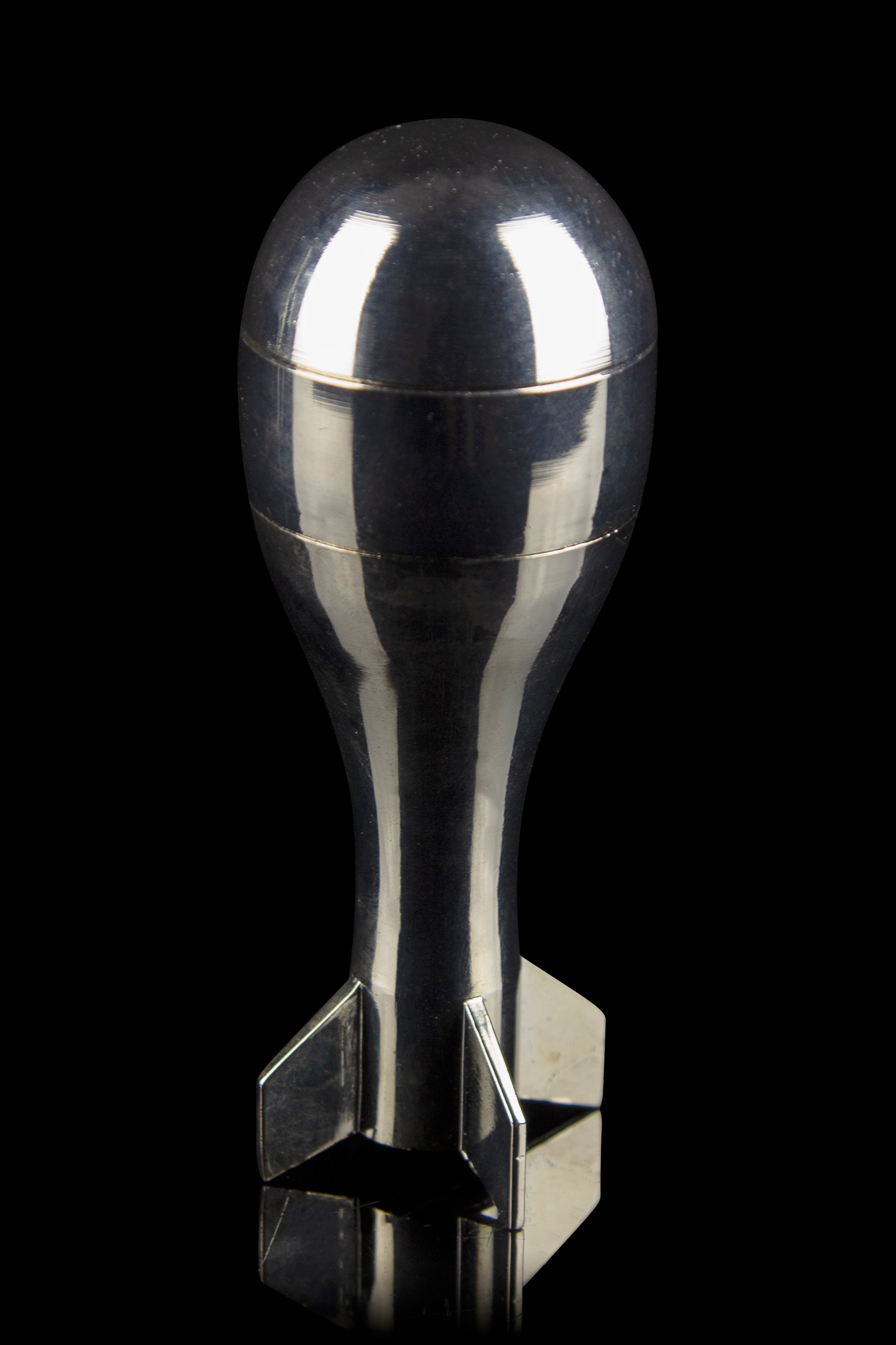 Polished silver cannabis oil burner resembling a bomb shape, studio shot on black background.