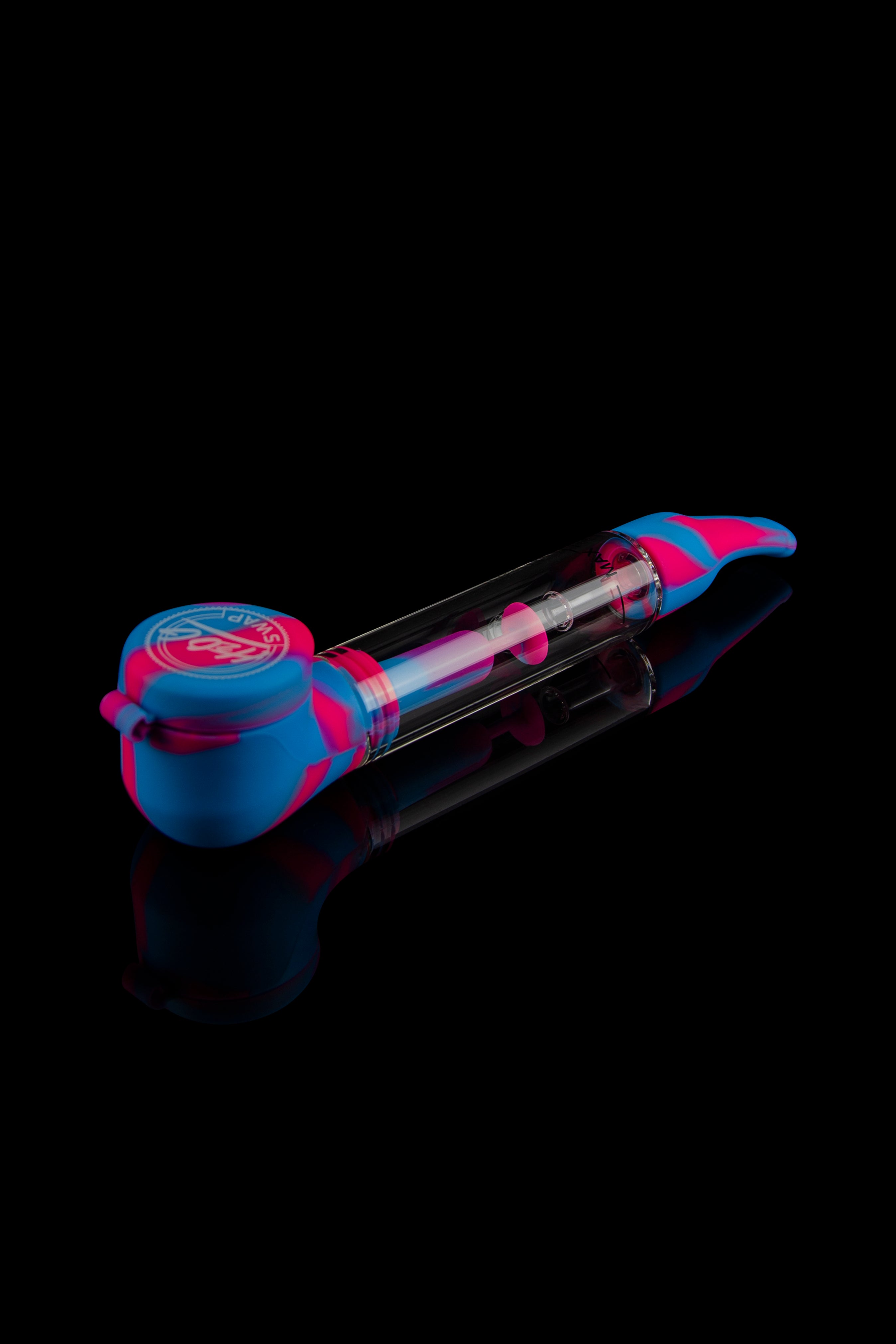 Silicone cannabis oil rig with glass chamber, isolated on black.