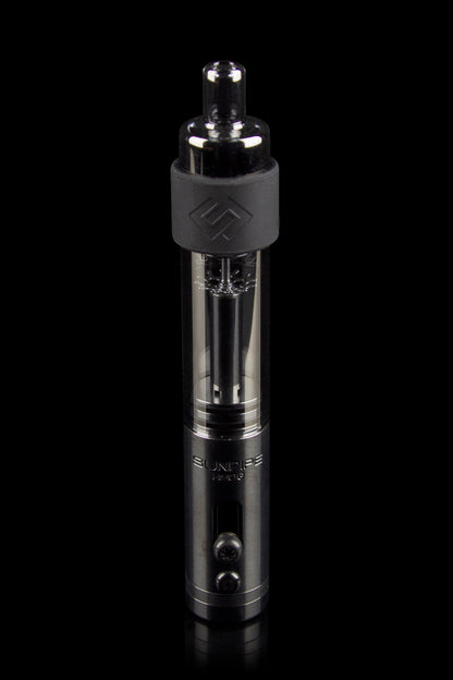 Black cannabis vaporizer pen with a clear cartridge visible, studio shot on a reflective surface.