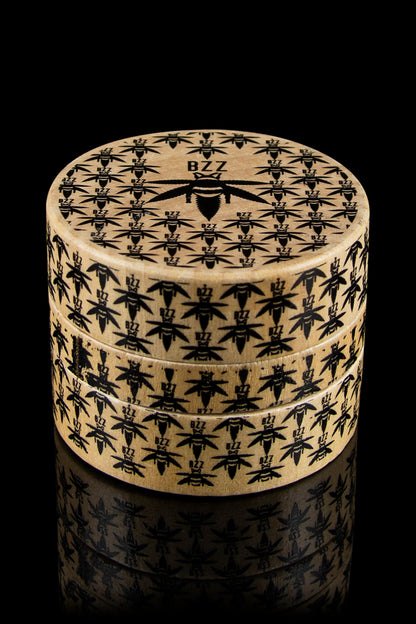 A stack of cylindrical containers with an all-over pattern of cannabis leaves, branded with "BZZ" on the top container.