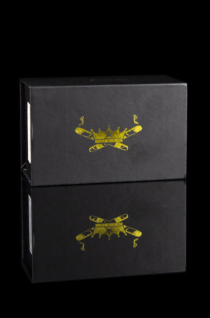 Two black boxes stacked, each embossed with a golden crossed-joint design and subtle smoke details.