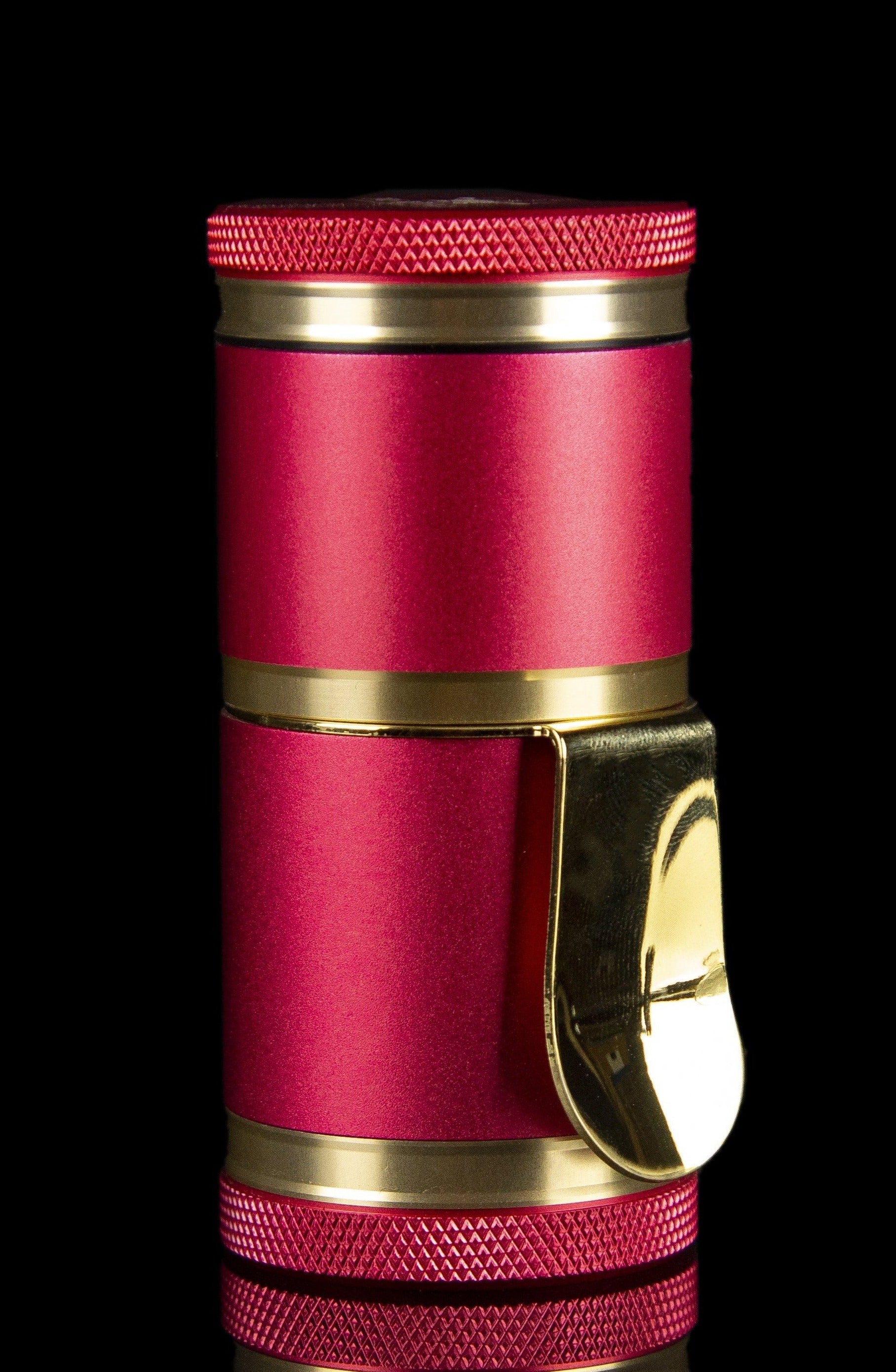 Pink and gold cannabis grinder with textured grip.