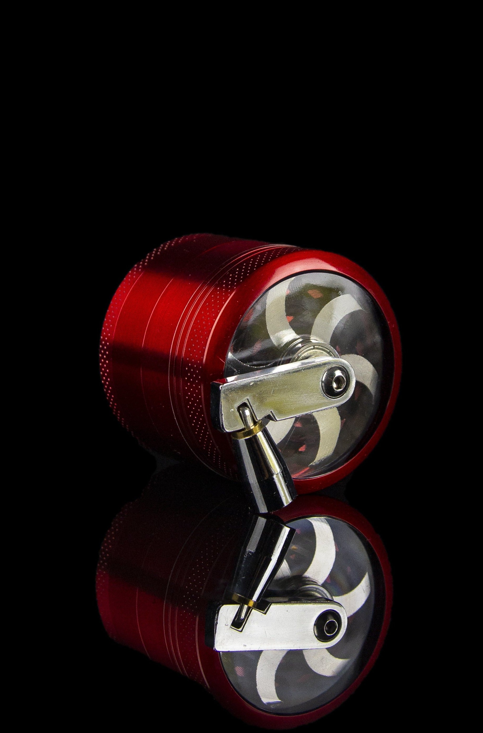 Red cannabis grinder disassembled, revealing the internal grinding mechanism against a black background.