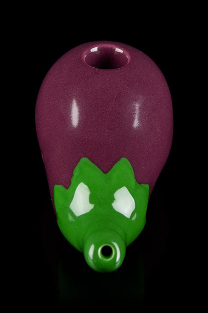 Glass pipe shaped like a dragon's head, featuring a burgundy body and green accents.
