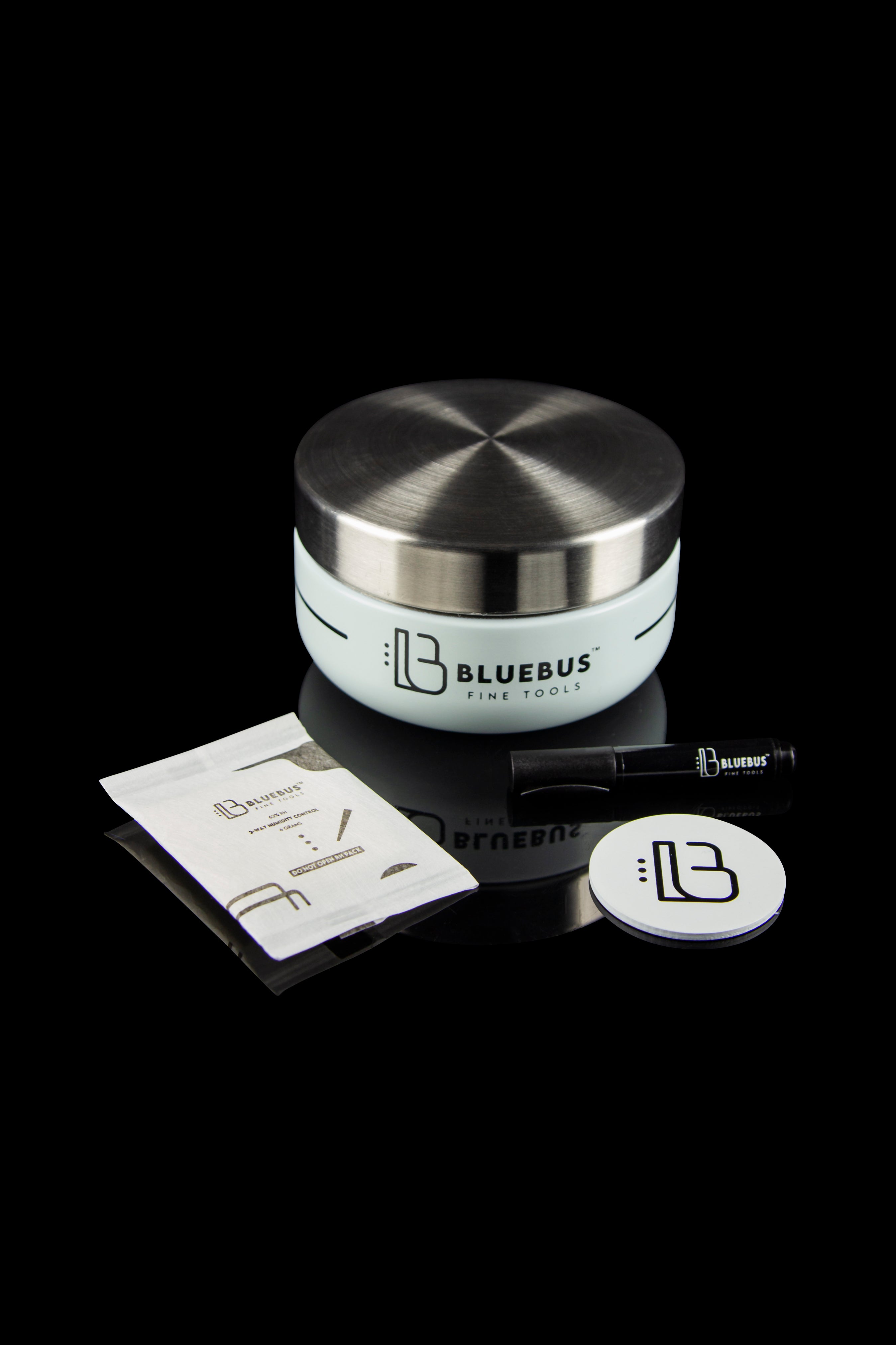Stainless steel cannabis storage jar and tools from Bluebus Fine Tools, displayed on a reflective black surface.