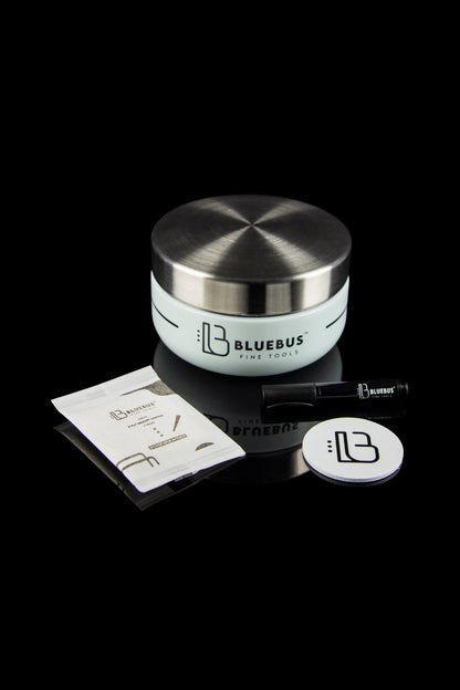 Stainless steel cannabis storage jar and tools from Bluebus Fine Tools, displayed on a reflective black surface.