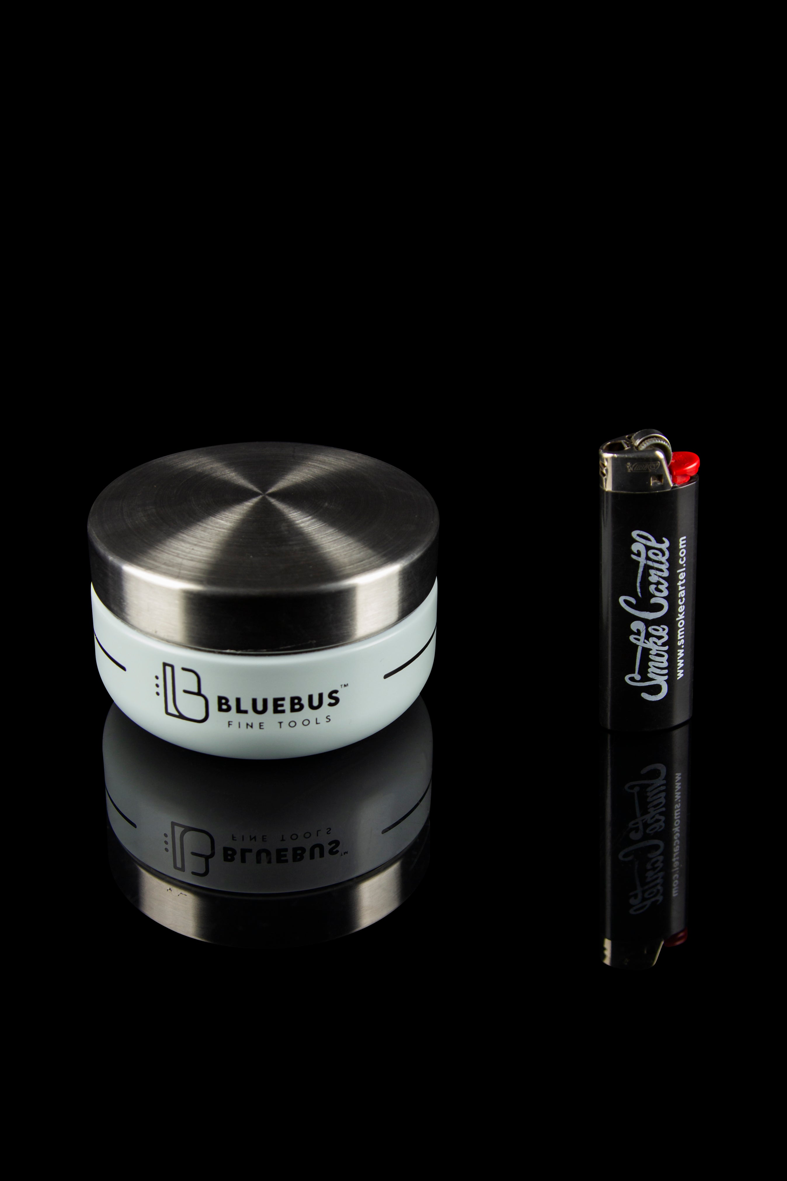 Sleek silver cannabis storage jar with a branded lighter on a black reflective surface.