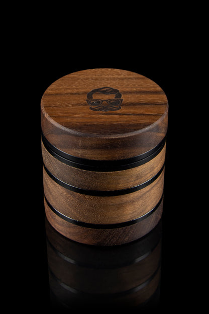 Wooden cannabis grinder with a skull design, isolated on a black background.