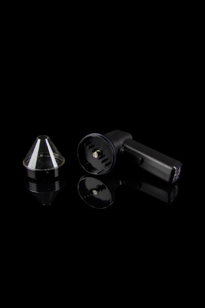 Black cannabis vaporizer components displayed on a reflective surface.